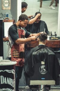 Barber skillfully cutting hair in a trendy barbershop with modern decor and relaxed atmosphere.